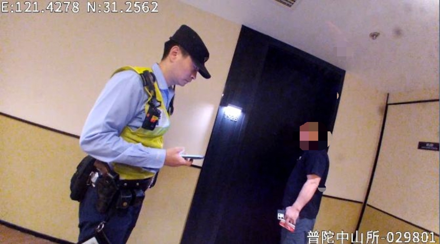 普陀民警在酒店房门前核查情况,门内男子面部保留原图马赛克